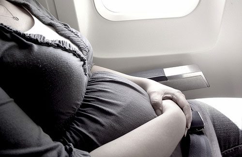 uma mulher grávida em um avião