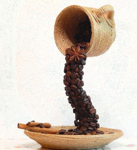 la taza de café en grano con sus propias manos