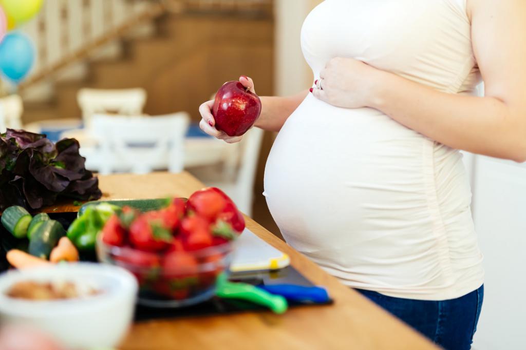 pregnant woman eating an Apple