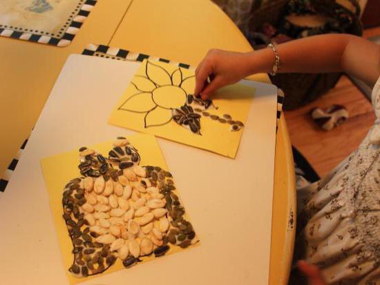 fazendo com as mãos o artesanato feito a partir de sementes de abóbora com as mãos pro outono
